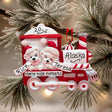A personalized Christmas train ornament hanging on a snowy pine branch. The red and white ornament features two polar bear children in Santa hats, the words 'North Pole Express,' 'Alaska,' and the names 'Rick' and 'Teresa,' with the number '2015' on the roof.