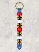 Four solid brass colonial-style bells on a blue leather strap with red & white keepers