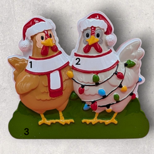 A Christmas ornament of 2 chickens wearing Santa caps with 3 areas for personalization